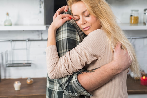 Mężczyzna przytulenie z blond kobietą w kuchni