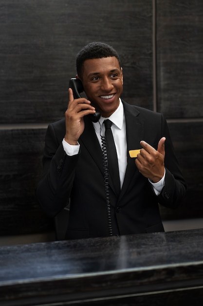 Bezpłatne zdjęcie mężczyzna recepcjonista w eleganckim garniturze w godzinach pracy