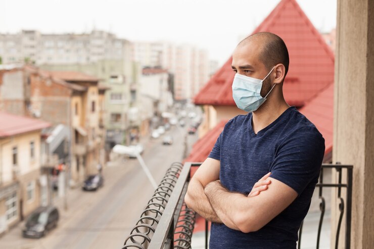 Bezpłatny plik Zdjęcie mężczyzna relaksuje się na balkonie podczas epidemii koronawirusa.