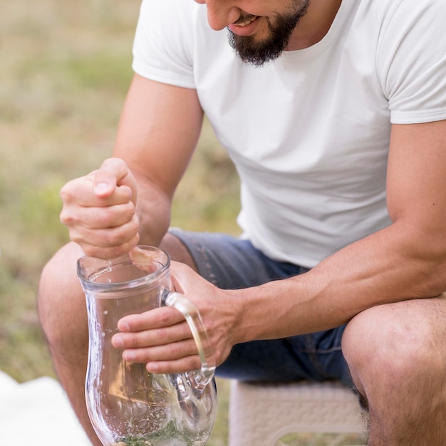 Bezpłatne zdjęcie mężczyzna robi lemoniadę na zewnątrz