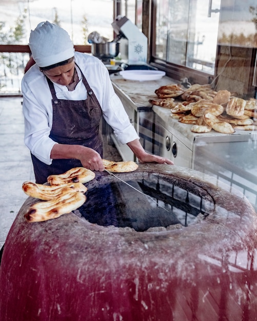 Mężczyzna robią widok boczny tradycyjnego chleba tandir