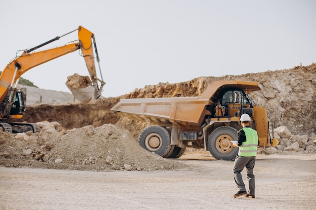 Mężczyzna robotnik z buldożerem w kamieniołomie piasku