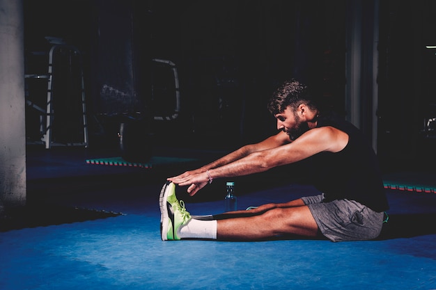 Bezpłatne zdjęcie mężczyzna rozciąganie w gym