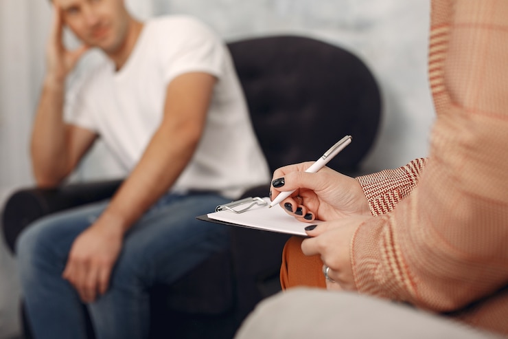 Bezpłatny plik Zdjęcie mężczyzna siedzi w biurze psychologa i rozmawia o problemach