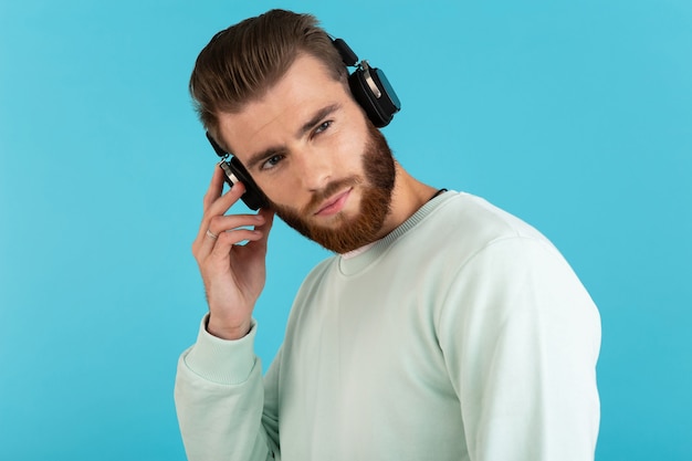 Bezpłatne zdjęcie mężczyzna słuchający muzyki na słuchawkach bezprzewodowych odizolowanych na niebiesko