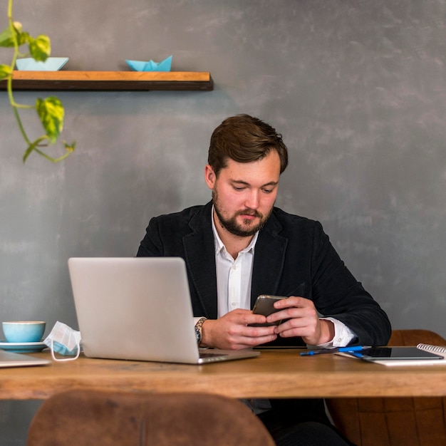 Mężczyzna sprawdza swój telefon w pracy