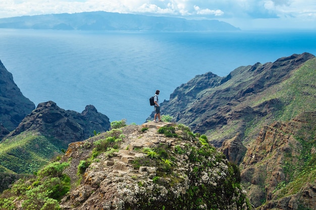 Mężczyzna stojący na wzgórzu na tle pięknego górskiego krajobrazu