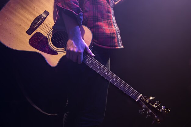 Mężczyzna trzyma gitarę akustyczną w jego rękach kopia przestrzeń.