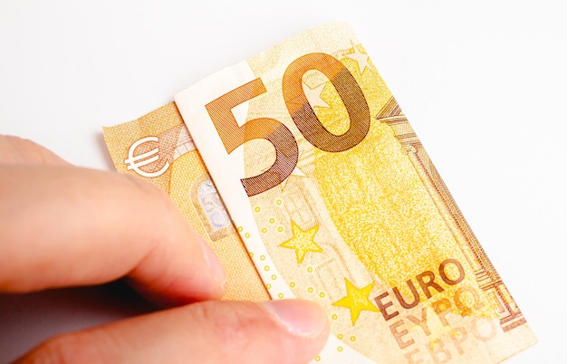 Mężczyzna trzymający banknot 50 euro na białym tle w fotografii zbliżeniowej