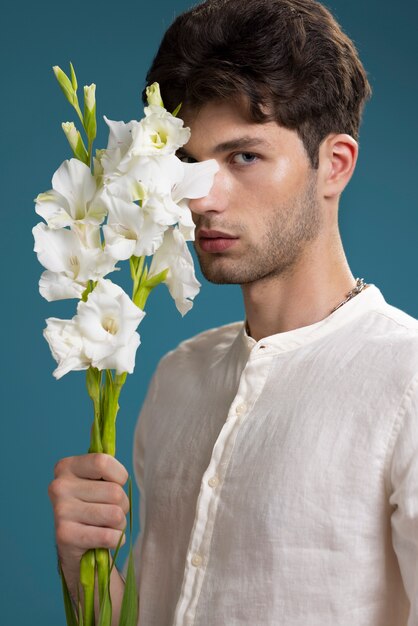 Mężczyzna trzymający białe kwiaty widok z boku