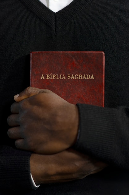 Bezpłatne zdjęcie mężczyzna trzymający księgę biblijną w kościele