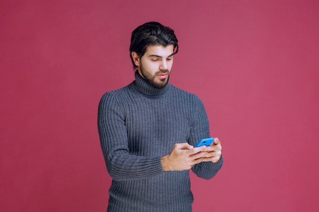 Mężczyzna Trzymający Smartfon, Czytający Wiadomości Lub Wysyłający Sms-y.