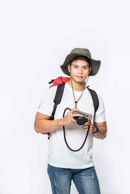 Mężczyzna ubrany do podróży w kapeluszu i biorąc aparat