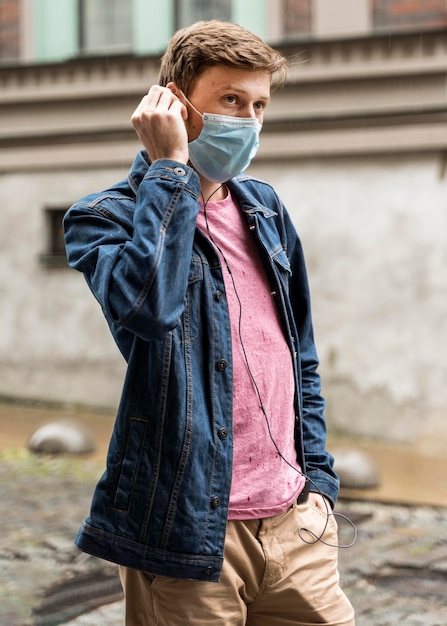 Mężczyzna ubrany w maskę medyczną na zewnątrz