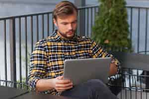 Bezpłatne zdjęcie mężczyzna używa laptop w sklep z kawą
