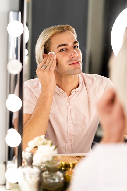 Mężczyzna używa wacików do czyszczenia skóry twarzy