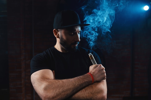 Bezpłatne zdjęcie mężczyzna vaping elektronicznego papierosa