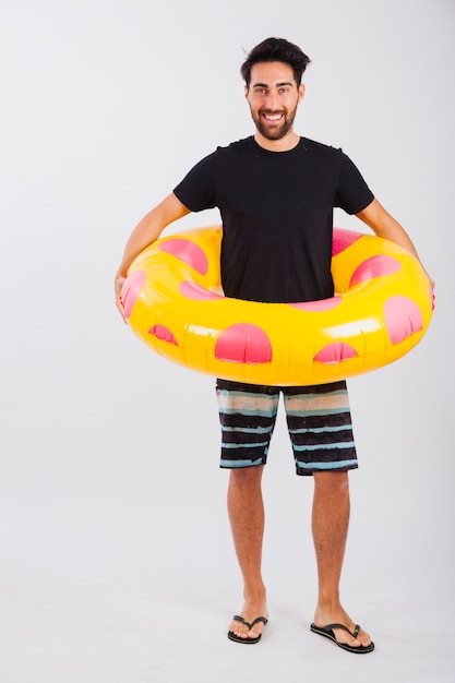 Bezpłatne zdjęcie mężczyzna w beachwear z pływającą rurkę wokół jego talii