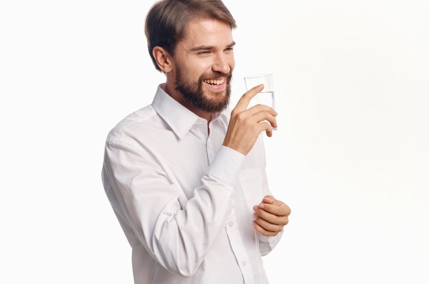 Mężczyzna w białej koszuli szklanka wody jasne tło