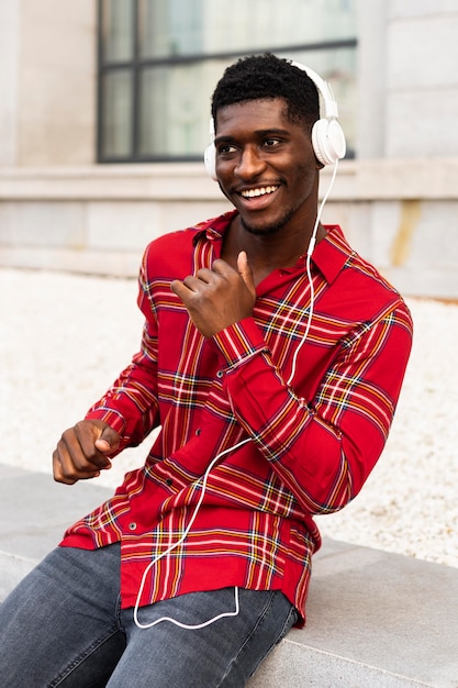 Bezpłatne zdjęcie mężczyzna w czerwonej koszuli, taniec i słuchanie muzyki