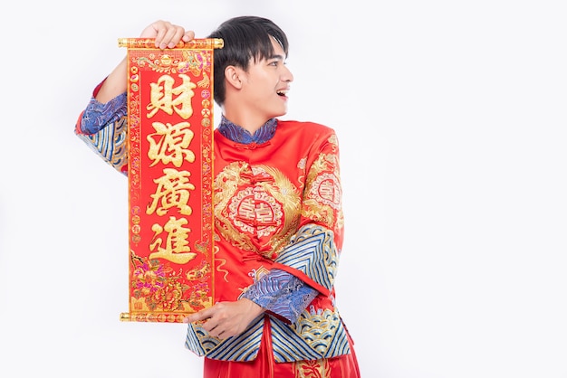 Mężczyzna w garniturze Cheongsam daje rodzinie chińską kartkę z życzeniami na szczęście w chiński nowy rok