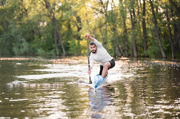 Mężczyzna w kajakowym paddling długim strzale