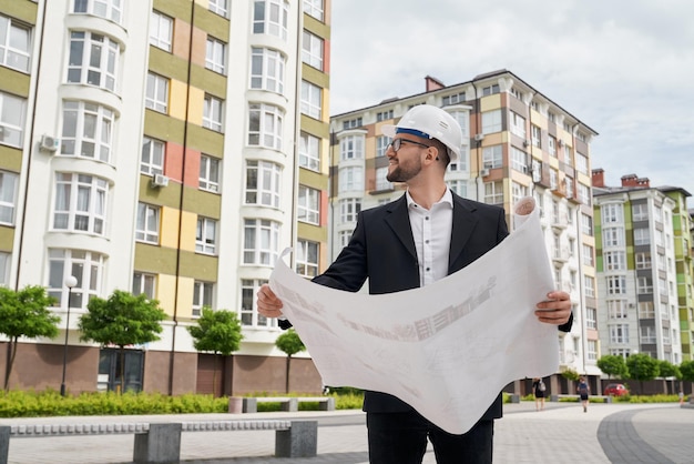 Mężczyzna W Kasku Z Architektonicznymi Rysunkami Konstrukcyjnymi