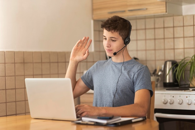 Mężczyzna w kwarantannie w kuchni pracuje na laptopie