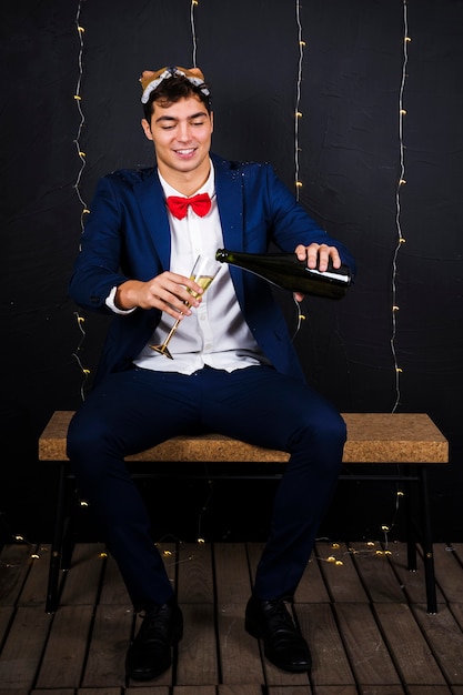 Mężczyzna w lisa masce na głowie z szkłem i butelką szampan