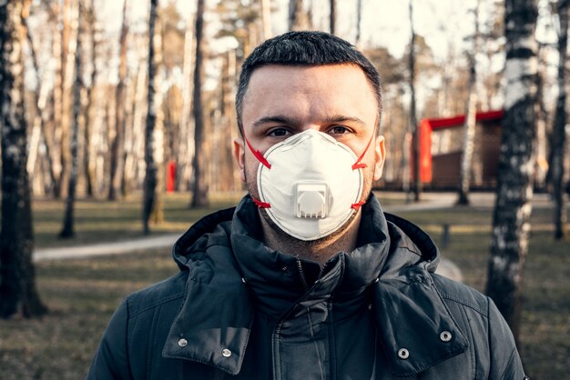 Mężczyzna w masce ochronnej w pustym parku. pandemia koronawirusa.