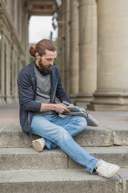 Mężczyzna w mieście wyciąga laptop