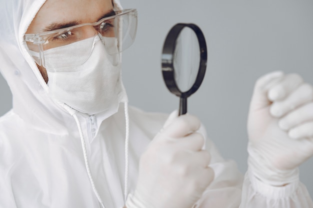 Bezpłatne zdjęcie mężczyzna w ochronnym kostiumu i szkłach pracuje przy laboratorium