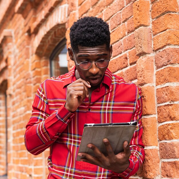 Mężczyzna w okularach i czyta ze swojego cyfrowego tabletu