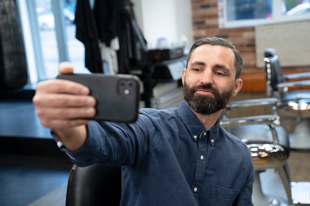 Mężczyzna w średnim ujęciu robi selfie