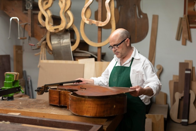 Mężczyzna w średnim wieku w swoim warsztacie instrumentów