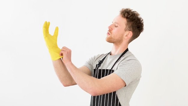 Bezpłatne zdjęcie mężczyzna wkłada rękawiczki do czyszczenia
