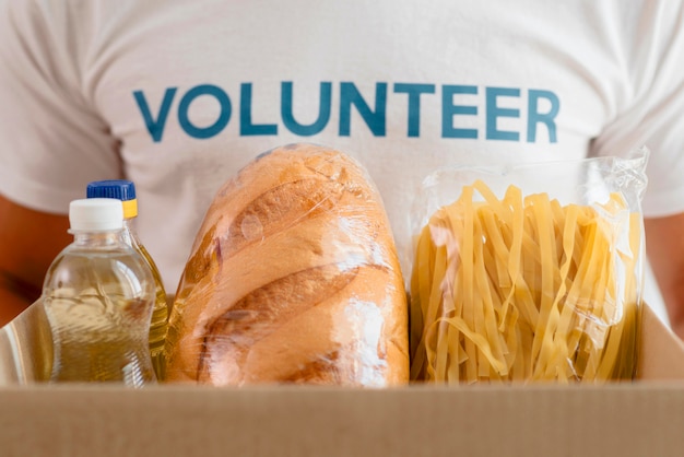 Bezpłatne zdjęcie mężczyzna wolontariusz trzyma pudełko z prowizjami na cele charytatywne