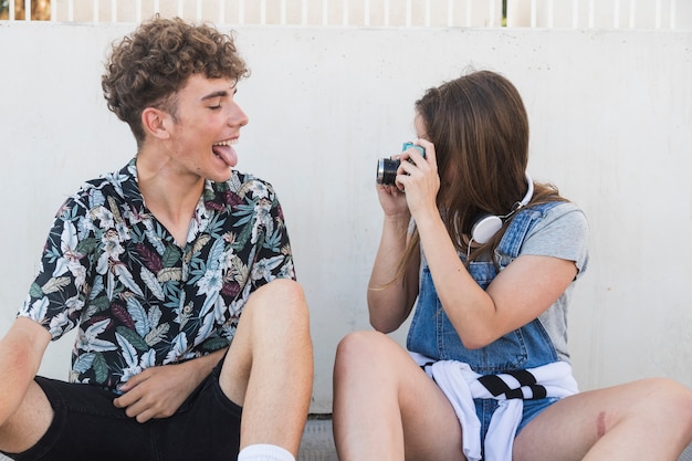 Mężczyzna Wtyka Jej Język, Podczas Gdy Jej Dziewczyna Bierze Fotografię Z Kamerą