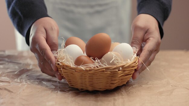 Bezpłatne zdjęcie mężczyzna wyjmuje jajka z koszyka i wkłada je do baxo mały robotnik na farmie