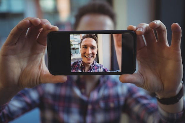 Mężczyzna wykonawczy przy selfie z telefonu komórkowego