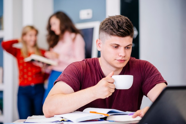 Mężczyzna z filiżanką pracuje na laptopie