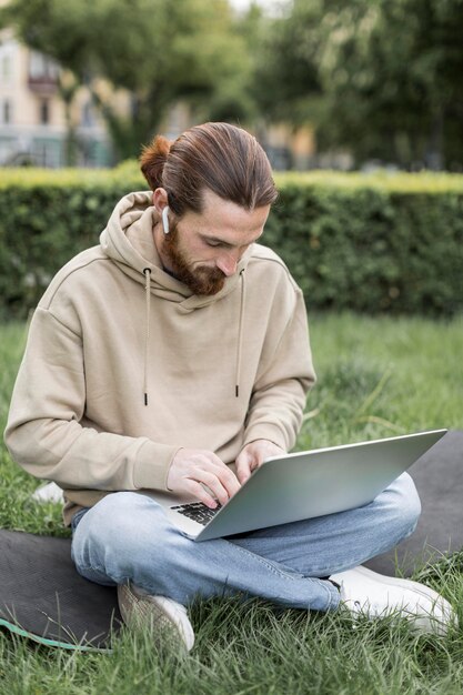 Mężczyzna z laptopem outdoors w miasto parku