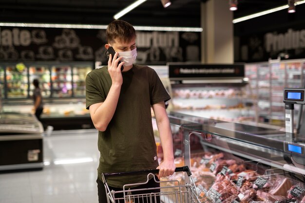 Mężczyzna z maseczką medyczną robi zakupy w supermarkecie