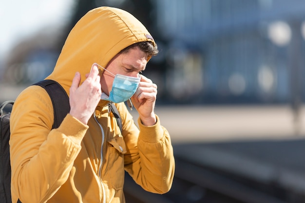 Mężczyzna z maską chirurgiczną plenerową