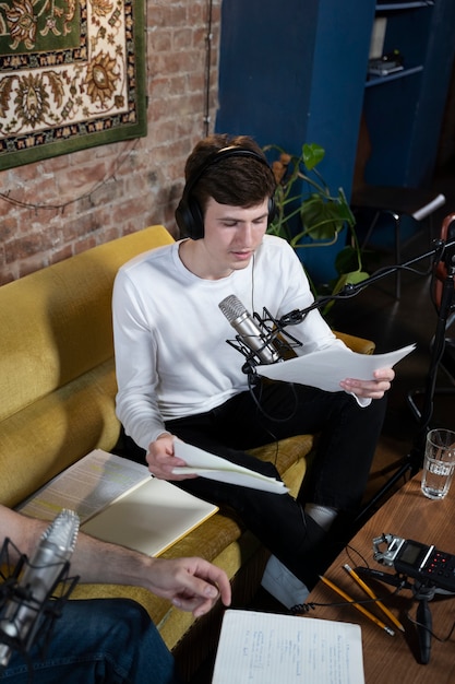 Mężczyzna z mikrofonem i słuchawkami prowadzący podcast w studiu