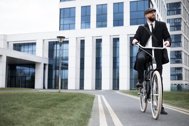 Mężczyzna z niskim kątem w garniturze jeździ na rowerze do pracy