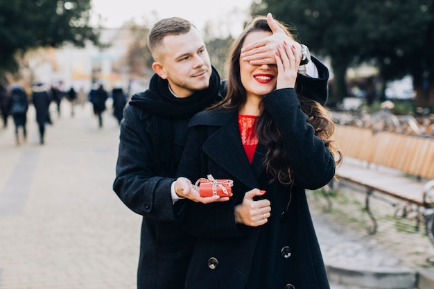 Bezpłatne zdjęcie mężczyzna z prezent zaskakującą młodą kobietą