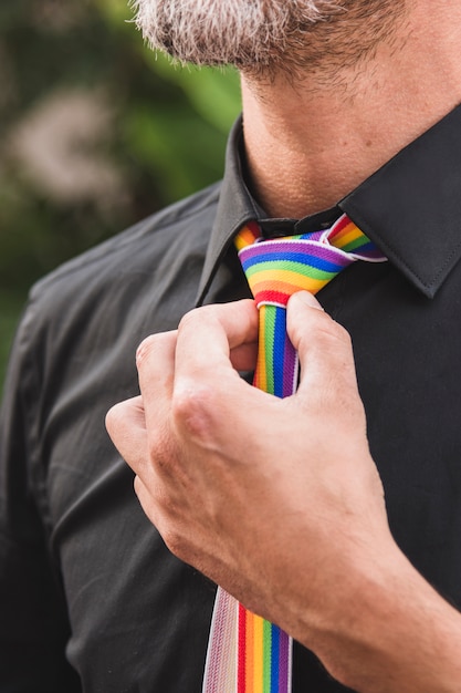 Bezpłatne zdjęcie mężczyzna z ręką blisko krawata w kolorach lgbt