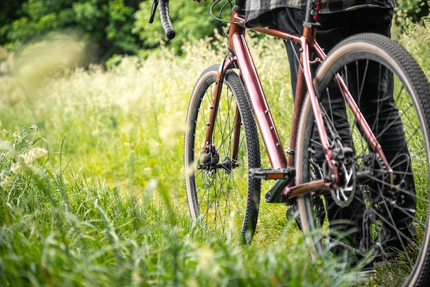 Bezpłatne zdjęcie mężczyzna z rowerem w lesie wśród trawy