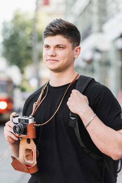 Mężczyzna z starą kamerą na ulicie